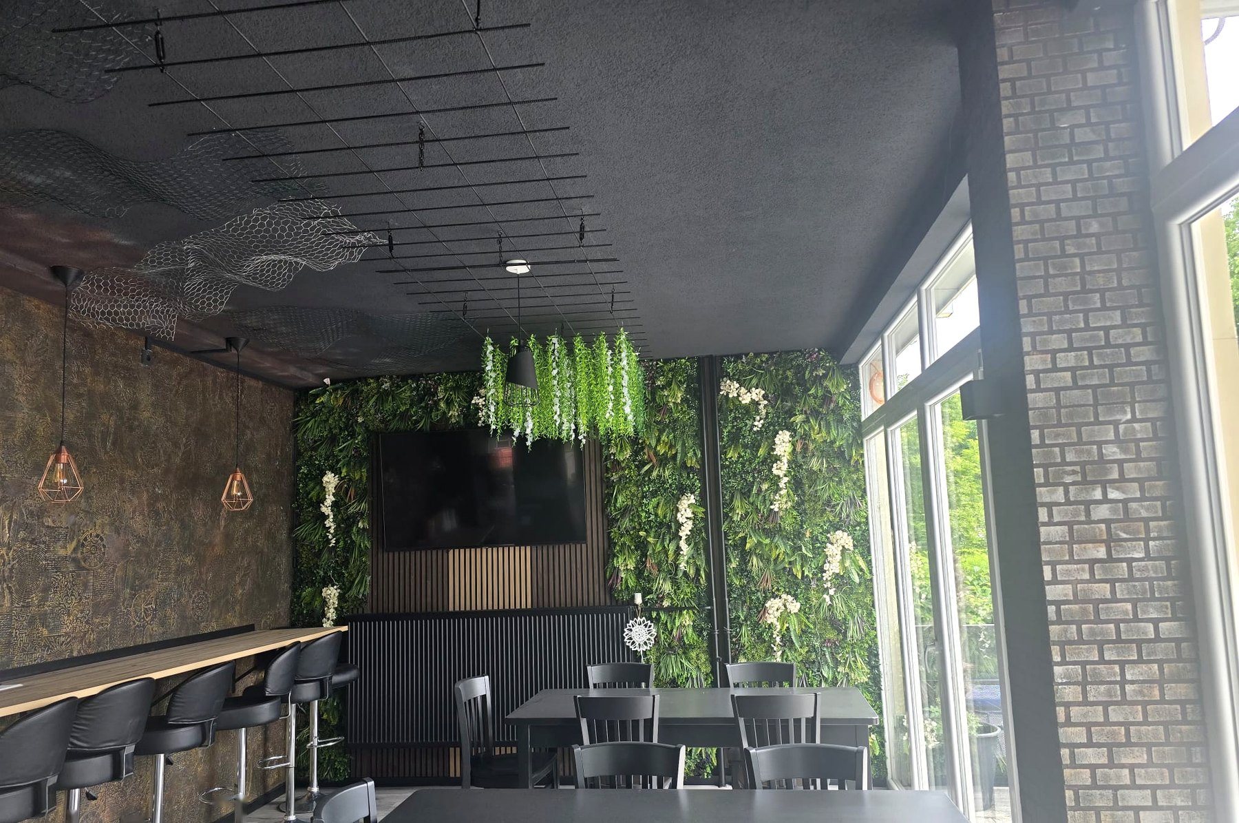 Roadhouse Sitzbereich mit Tischen und Pflanzenwand